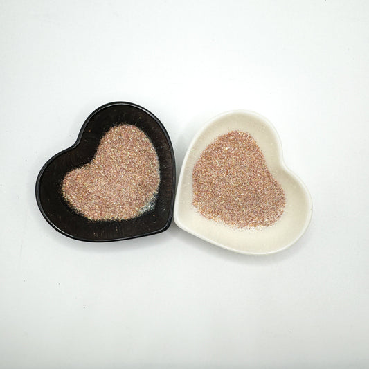 Two heart-shaped containers of glitter, one black and the other white, both showing an extra fine, light multicoloured glitter mix