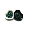 Two heart shaped containers, one black, one white, containing a Teal/Black/White chunky glitter mix.