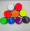 9 jars flipped upside to show the colours of pigments pastes. Colours shown, White, Electric Coral, Electric Orange, Elecrtic Yellow, Electric Green, Electric Blue, Electric Purple & Black on a white background.