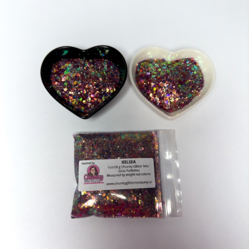 Two heart-shaped containers of glitter, one black and the other white, both showing a chunky glitter, multicolored glitter mix and a bag of glitter with a label that reads Kelsea.