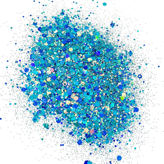 A pile of blue and turquoise colored chunky glitter, spread out on a surface.