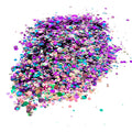 A pile of mixed colours of chunky glitter, including Pink/Gold/Purple/Green, on a white background.