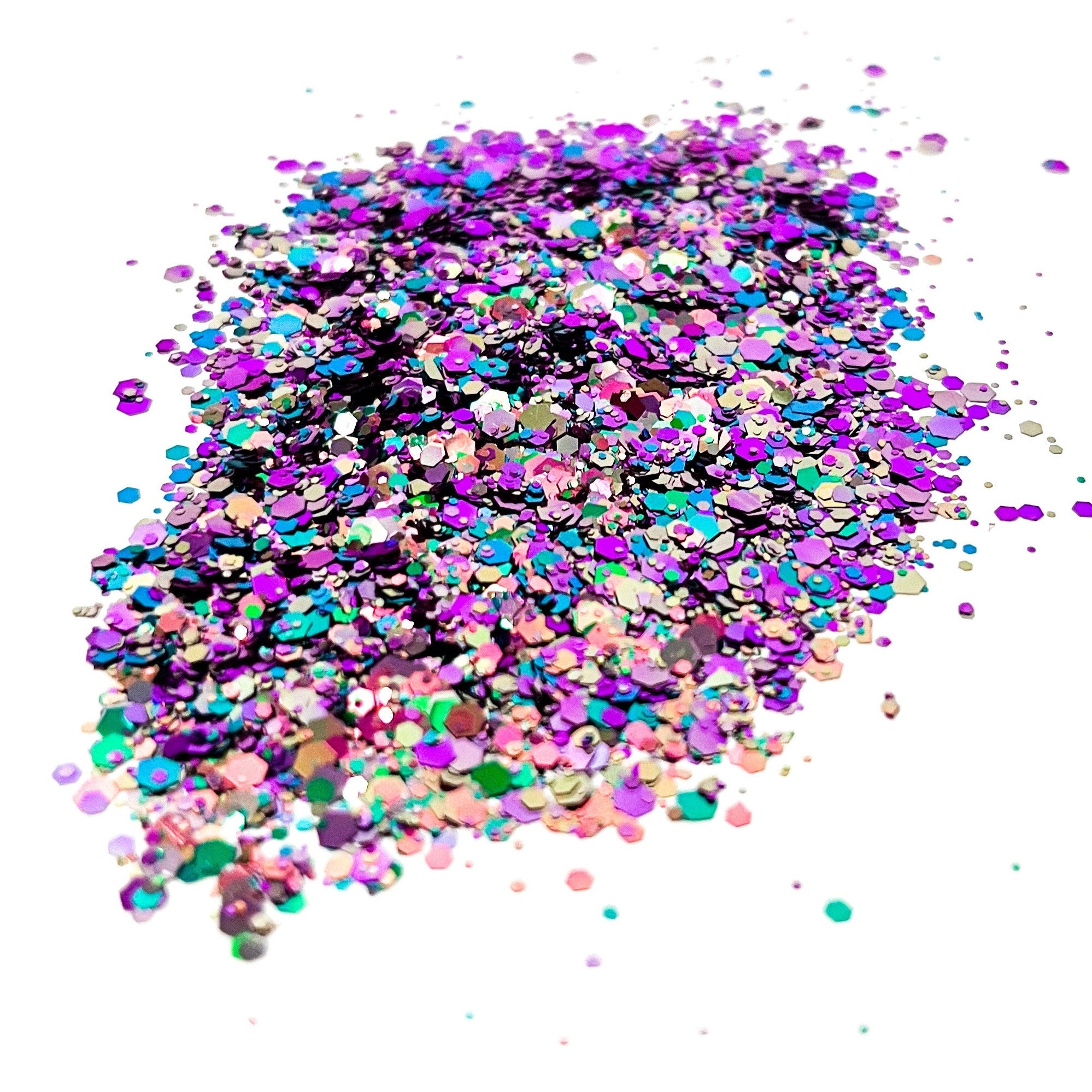 A pile of mixed colours of chunky glitter, including Pink/Gold/Purple/Green, on a white background.