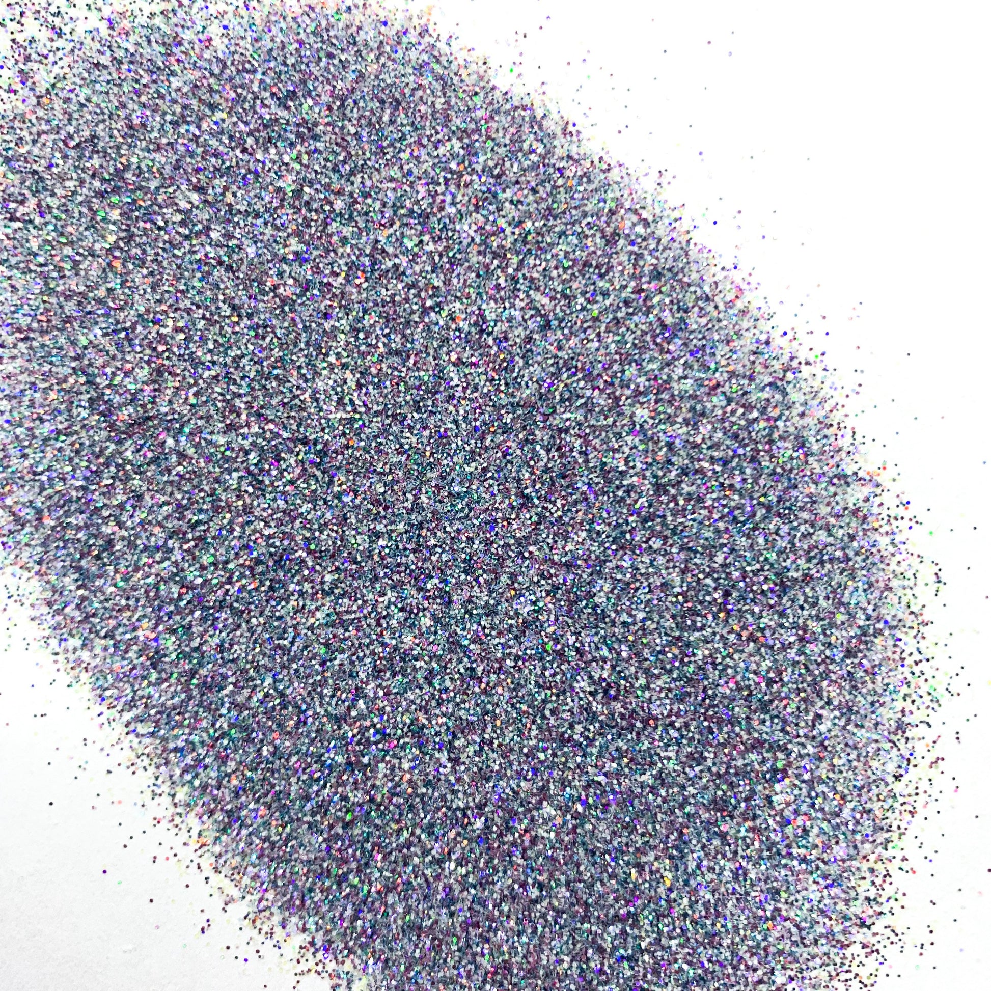 A pile of multicolored holographic glitter, with colors including blue and silver, spread out on a surface.