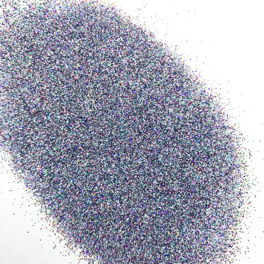 A pile of multicolored holographic glitter, with colors including blue and silver, spread out on a surface.