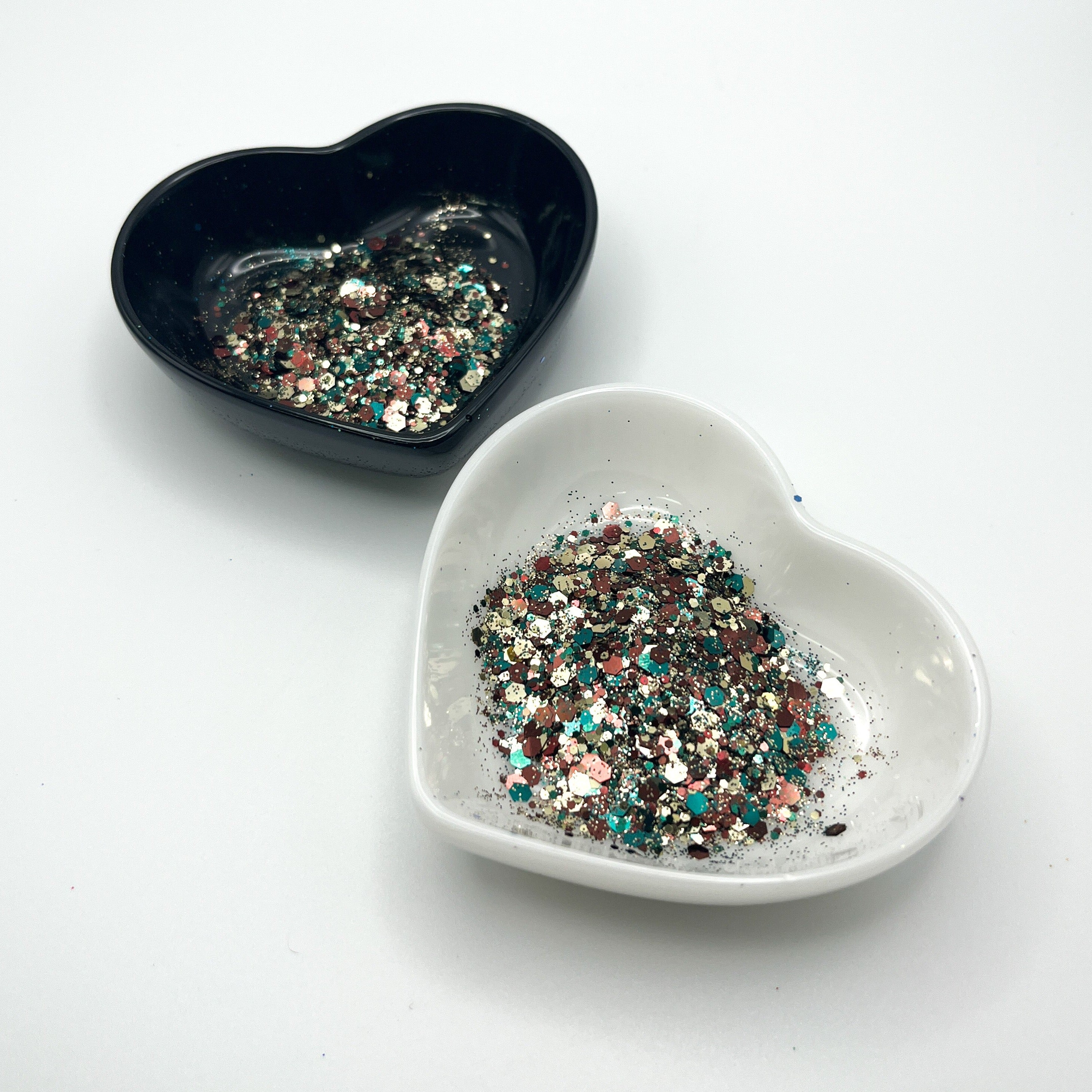 Two heart shaped containers, one black, one white, containing a Hunter Green/Brown/Gold chunky glitter mix.