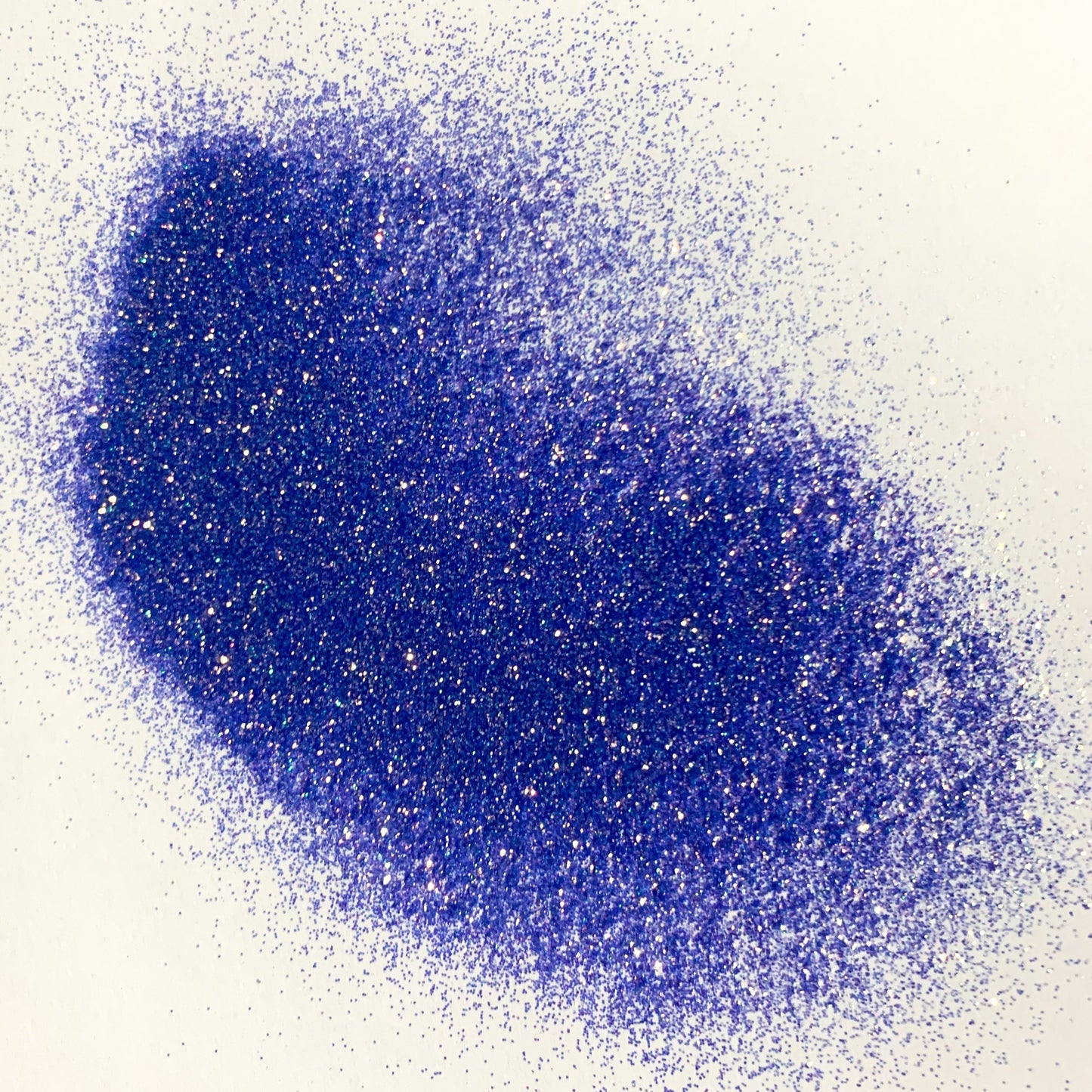 A pile of blue extra fine glitter on a white surface.