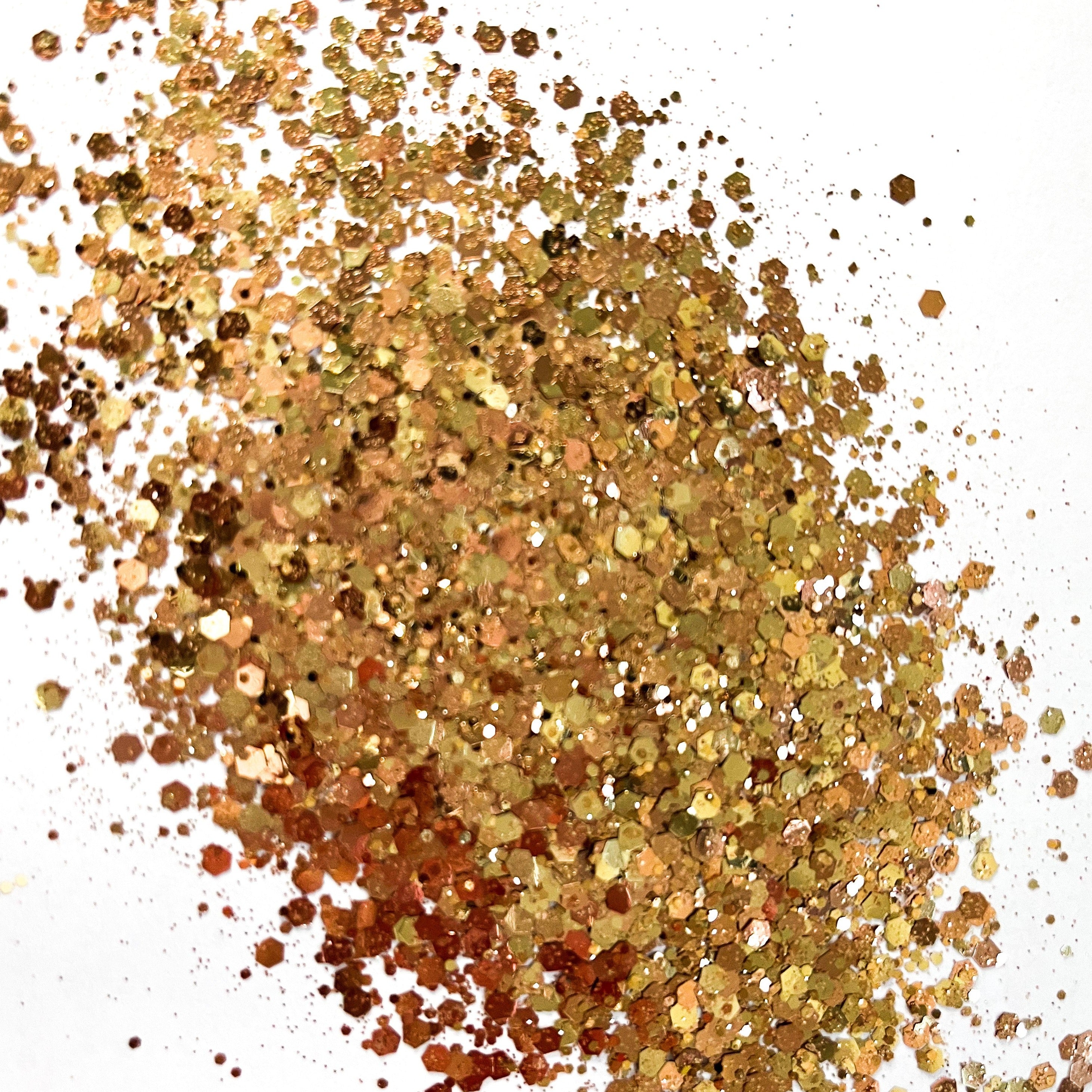 A rose gold and bronze chunky glitter mix on a white background.