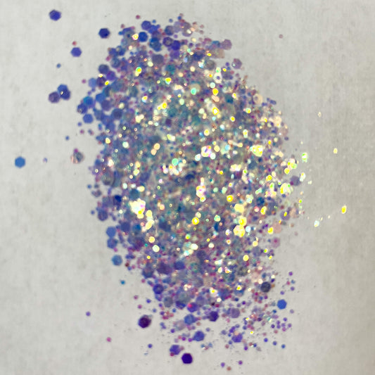 A close-up image of opal white chunky glitter spread on a surface.