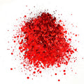A pile of red colored polyester glitter spread out on a white background.