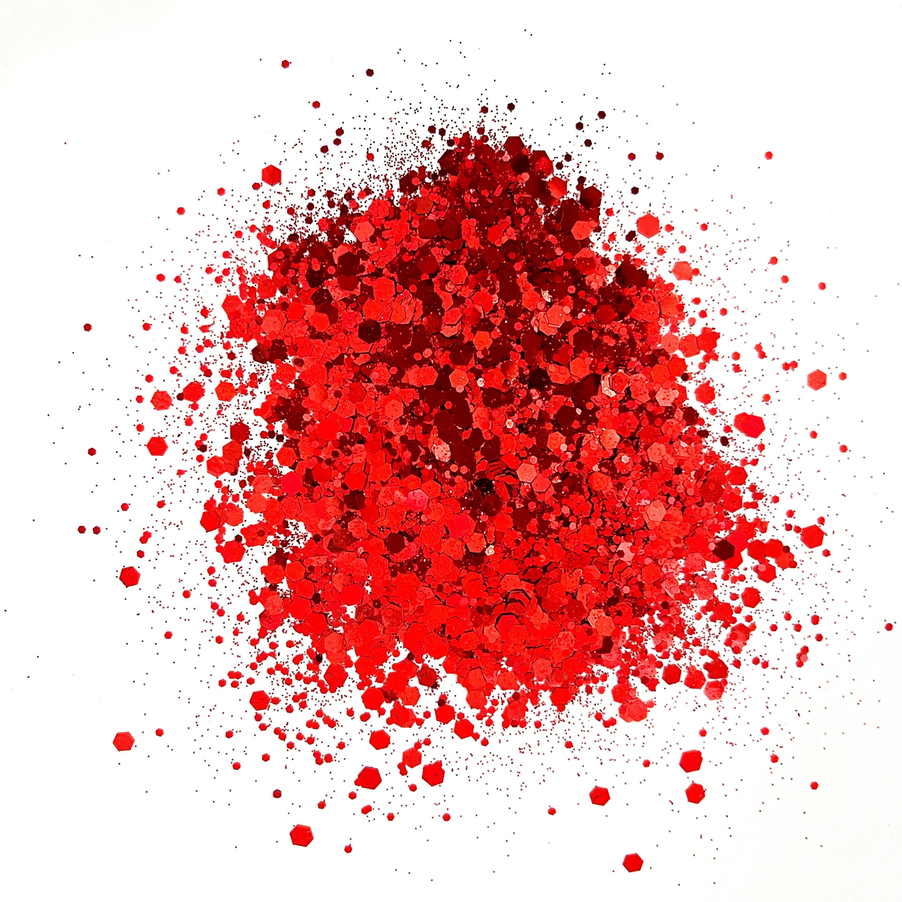 A pile of red colored polyester glitter spread out on a white background.