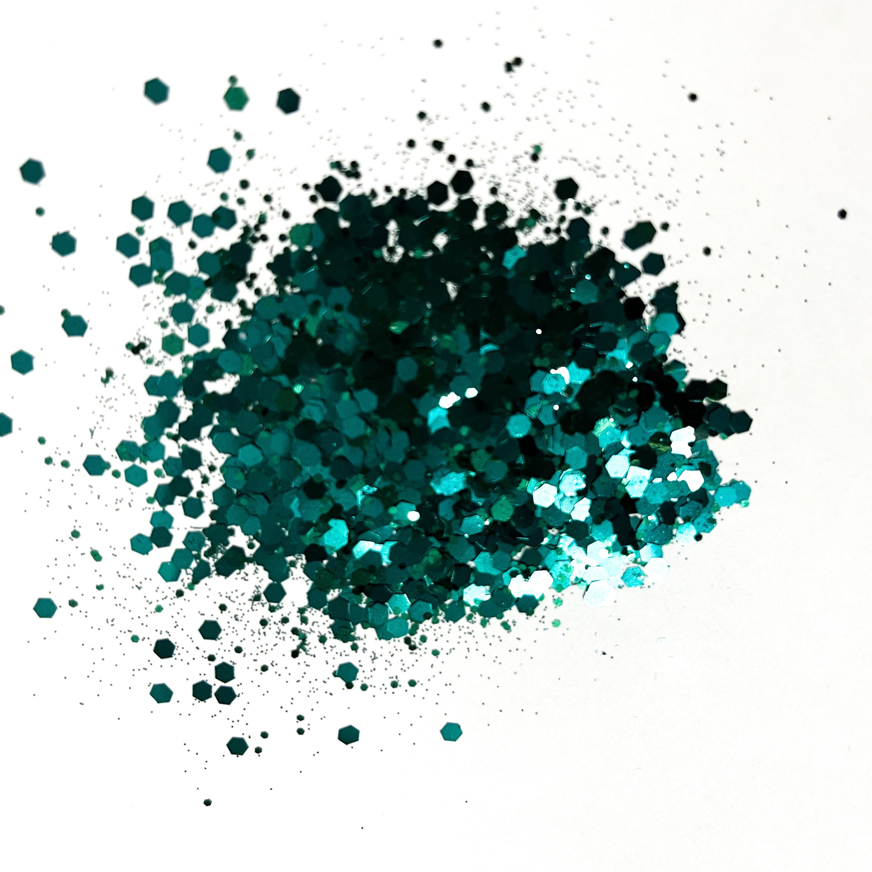 A pile of hunter green chunky glitter on a white background.