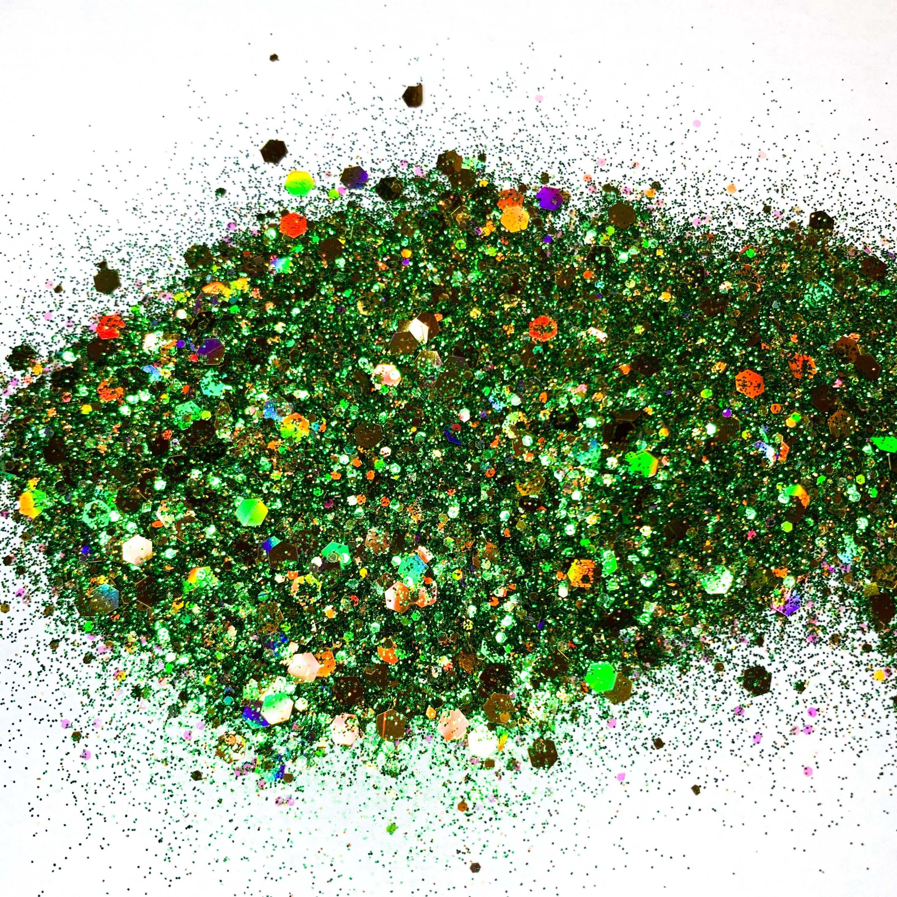 A close-up image of a mix of holographic gold and green glitter varying in size.