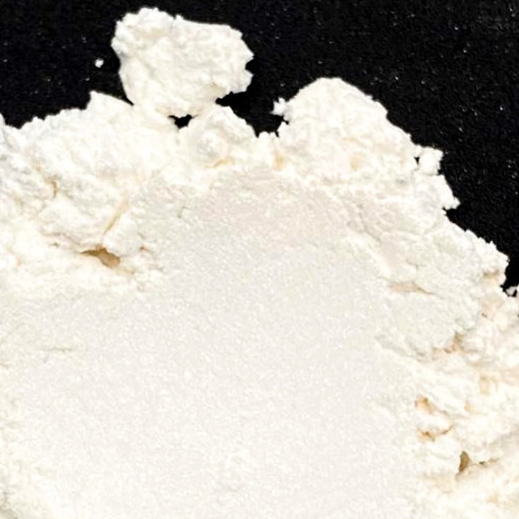 A close-up image of white mica powder against a black background.