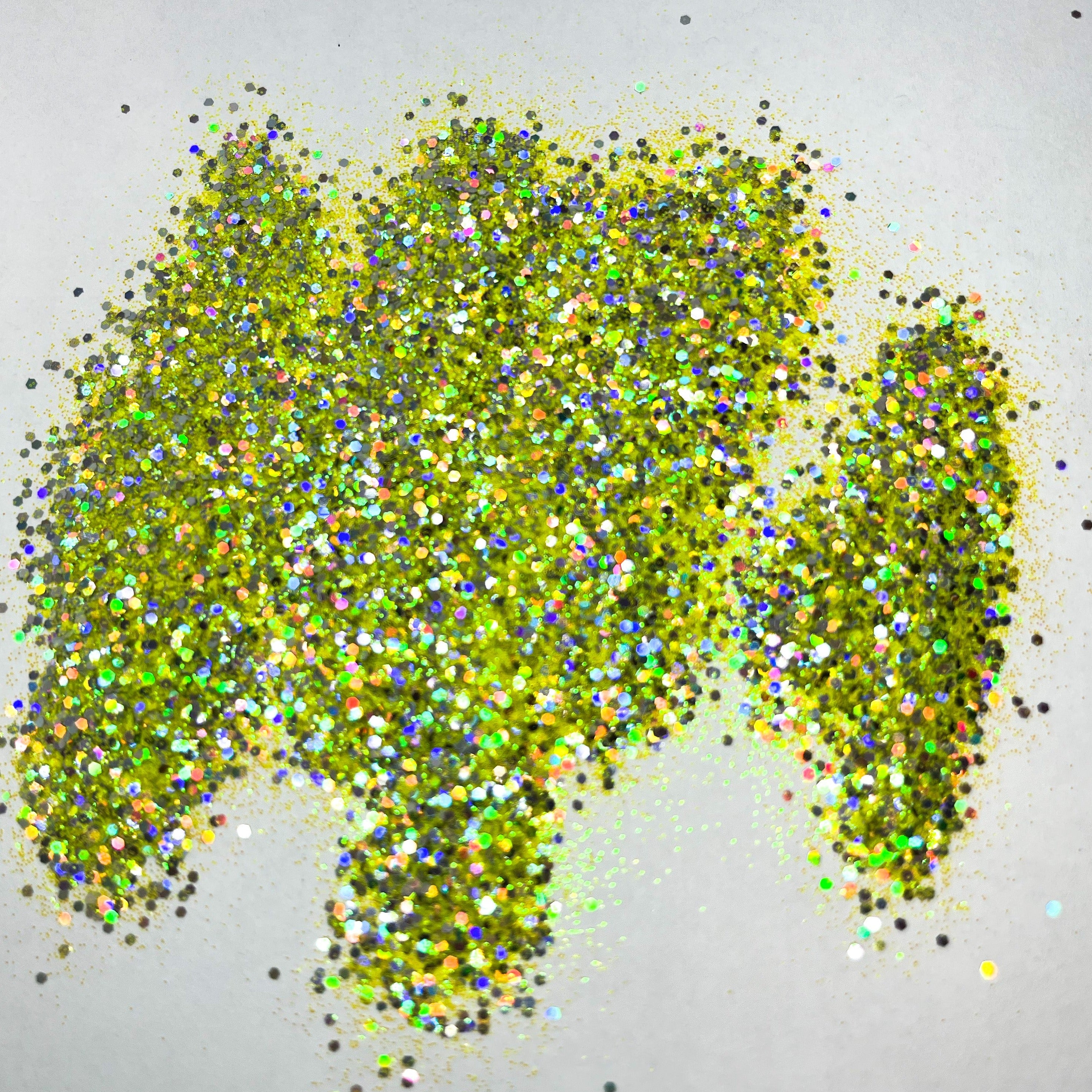 A pile of multicolored glitter, with a predominance of yellow hues, spread out on a surface.