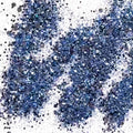 A pile of mixed colours of chunky glitter, including Blue/Black/Silver on a white background.