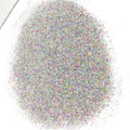 A pile of multicolored glitter, including pink, purple, and white, against a white background.