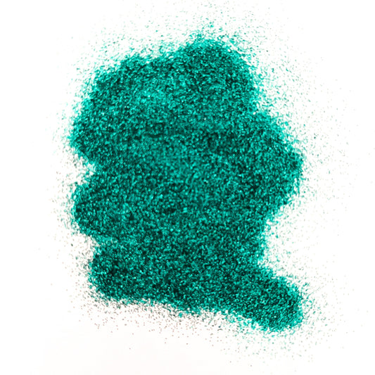 A pile of turquoise, extra fine glitter spread on a white surface.