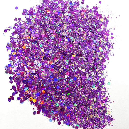A pile of purple holographic chunky glitter on a white background.