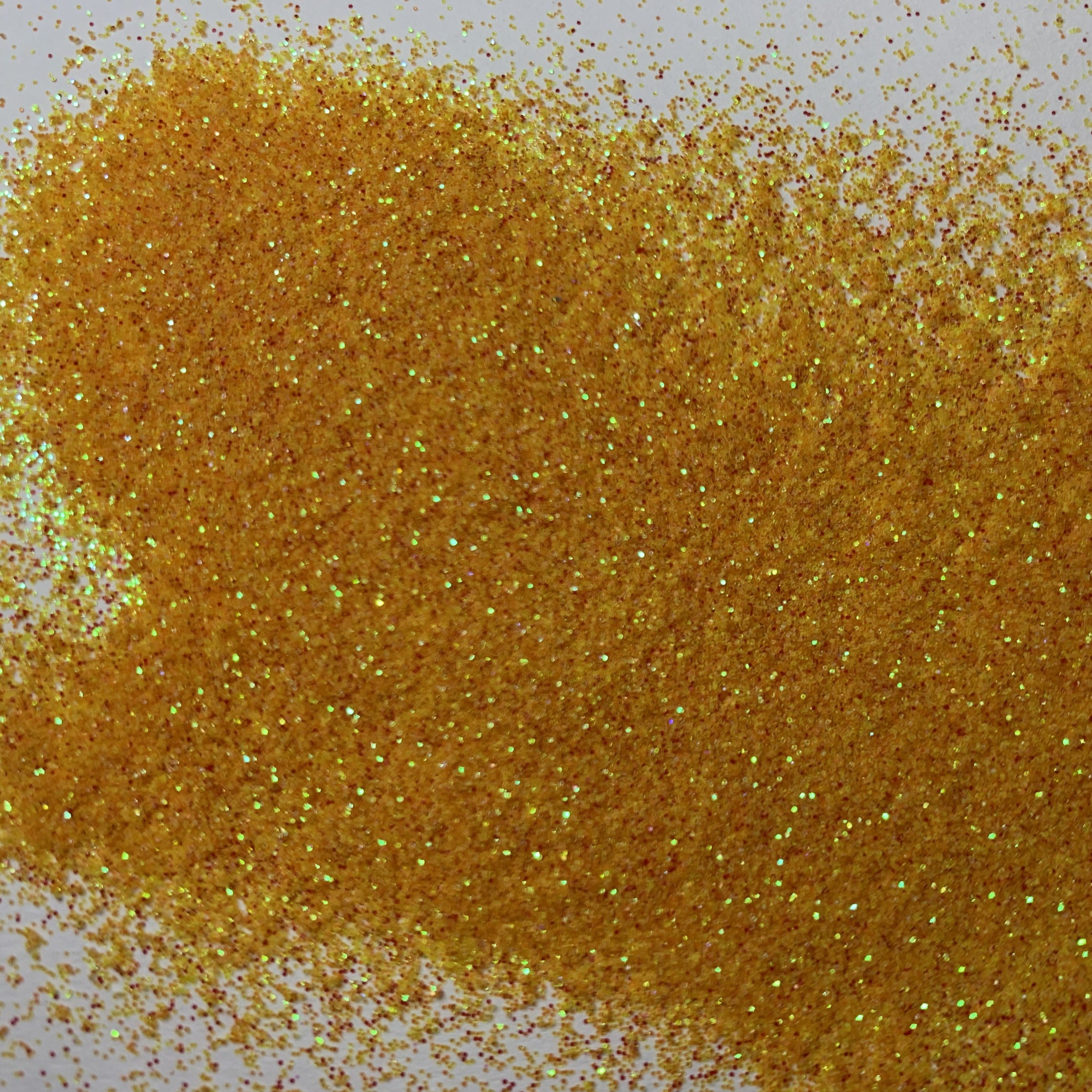 A close-up image of a sparkling, orange-colored glitter spread, with a blurred background.