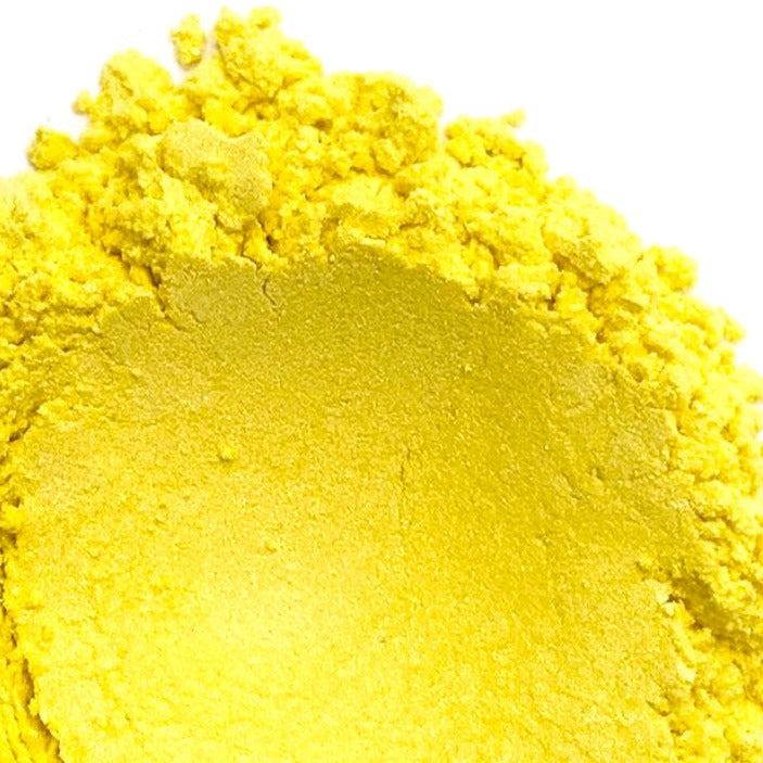 A pile of yellow mica powder on a white background.