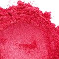 A pile of dark pink mica powder on a white background.