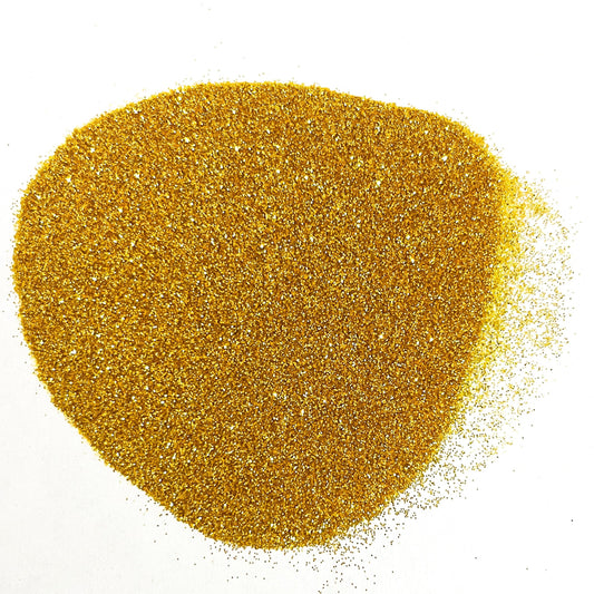 A pile of yellow metallic glitter on a white background