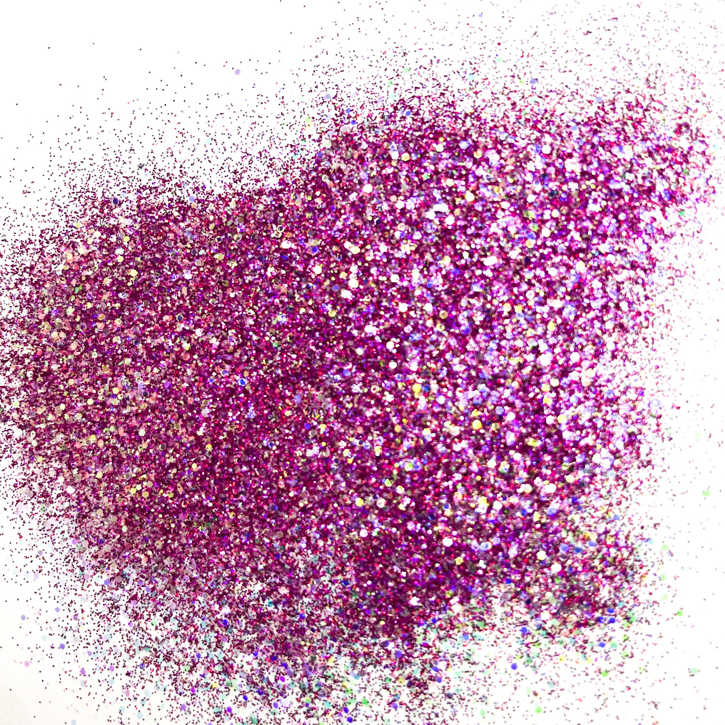 A pile of multicolored glitter, with a predominance of burgundy hues, spread out on a surface.