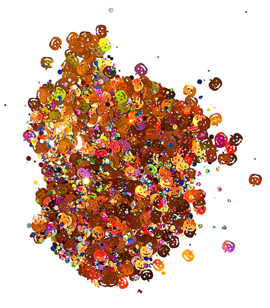 A pile of mixed colours of chunky glitter, including Rainbow Circles/Pumpkins on a white background.