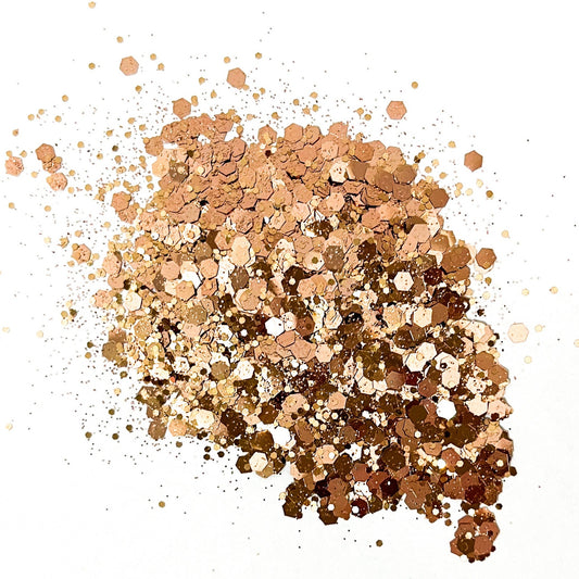 A pile of rose gold chunky glitter on a white background.