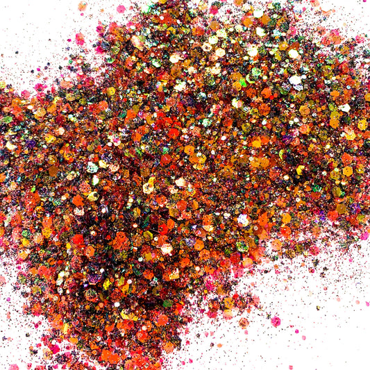 A close-up image of multicolored chunky glitter spread out on a surface.