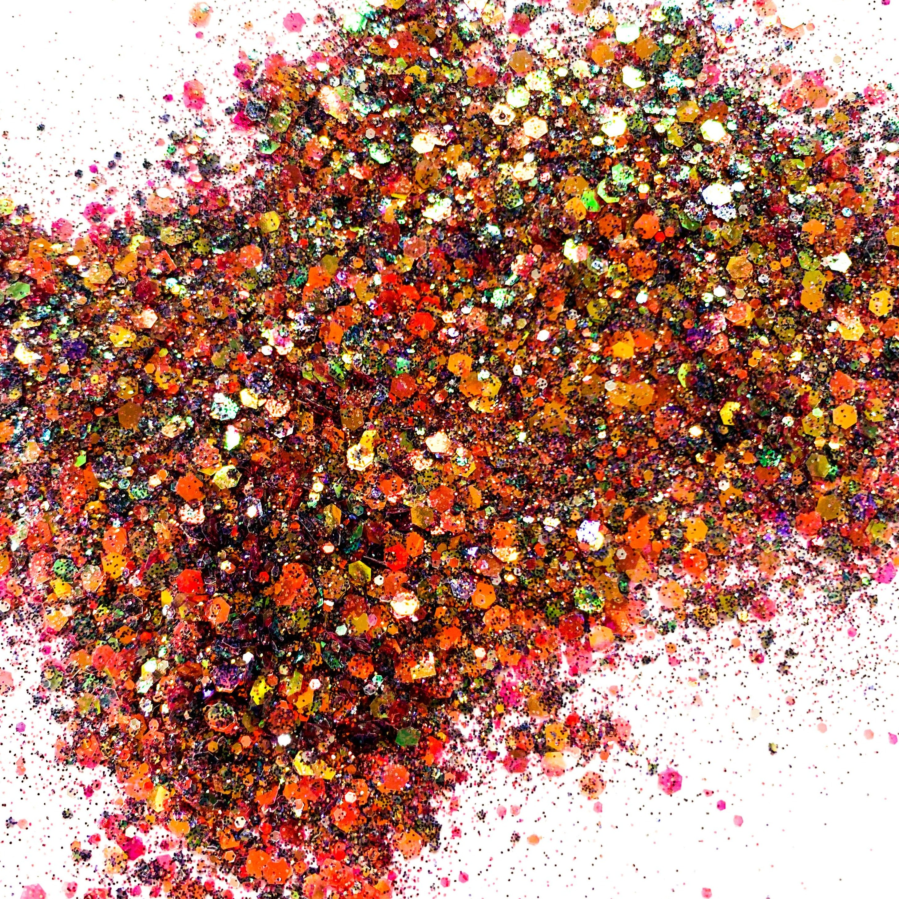 A close-up image of multicolored chunky glitter spread out on a surface.