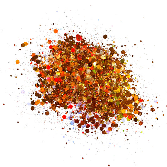 A pile of multicolored glitter, with shades of brown, orange, and yellow predominating.