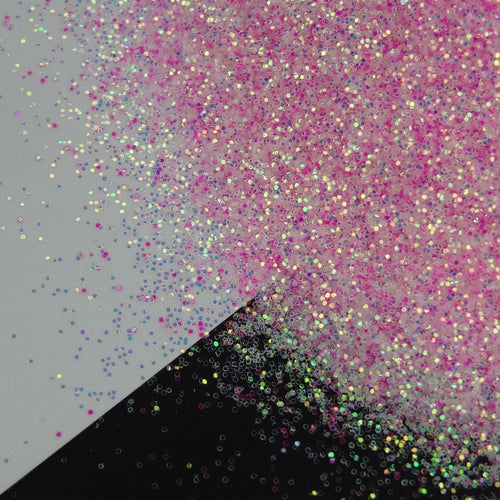 A pink extra fine glitter mix spread out on a black and white background.