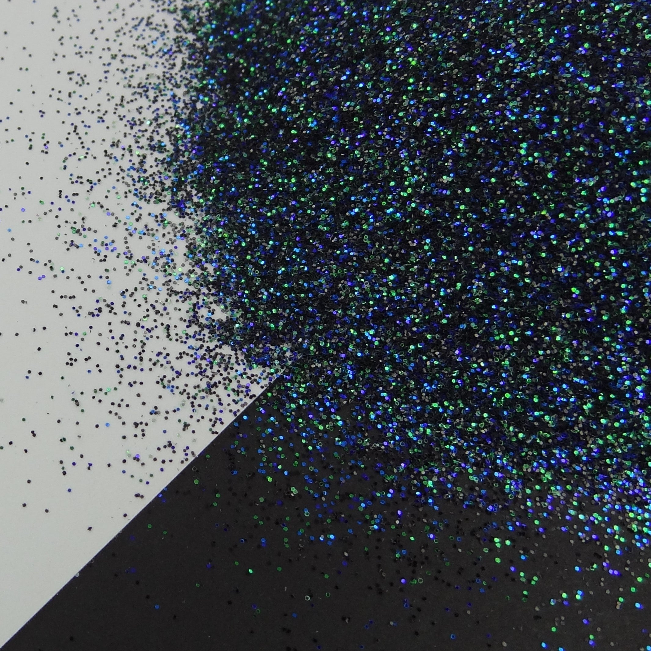 A dark extra fine glitter mix spread out on a black and white background.