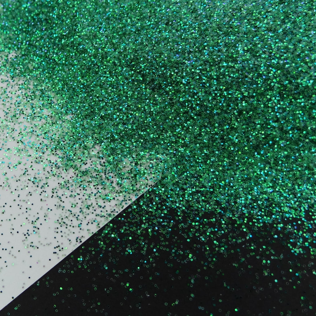 A green extra fine glitter mix spread out on a black and white background.