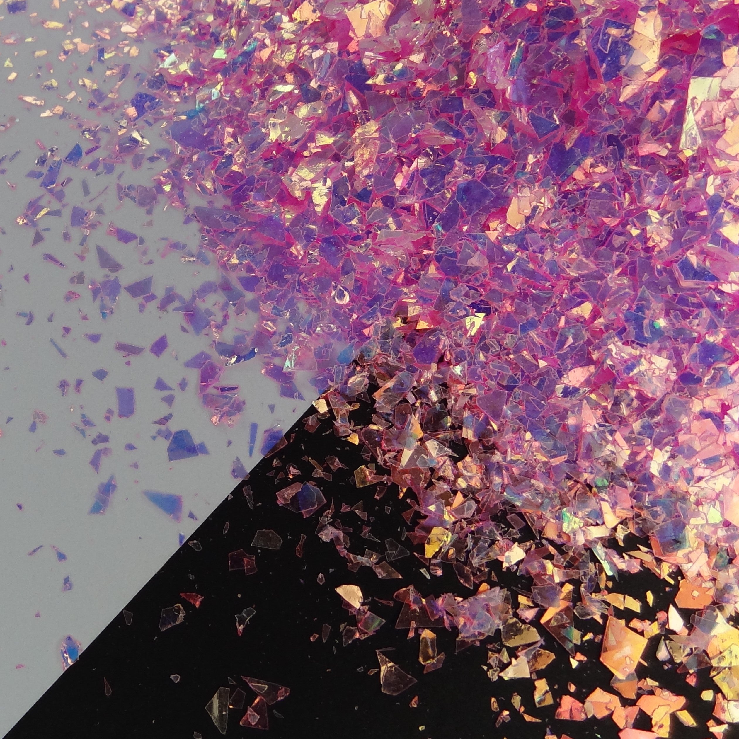 A pink irregular shard glitter spread out on a black and white background.