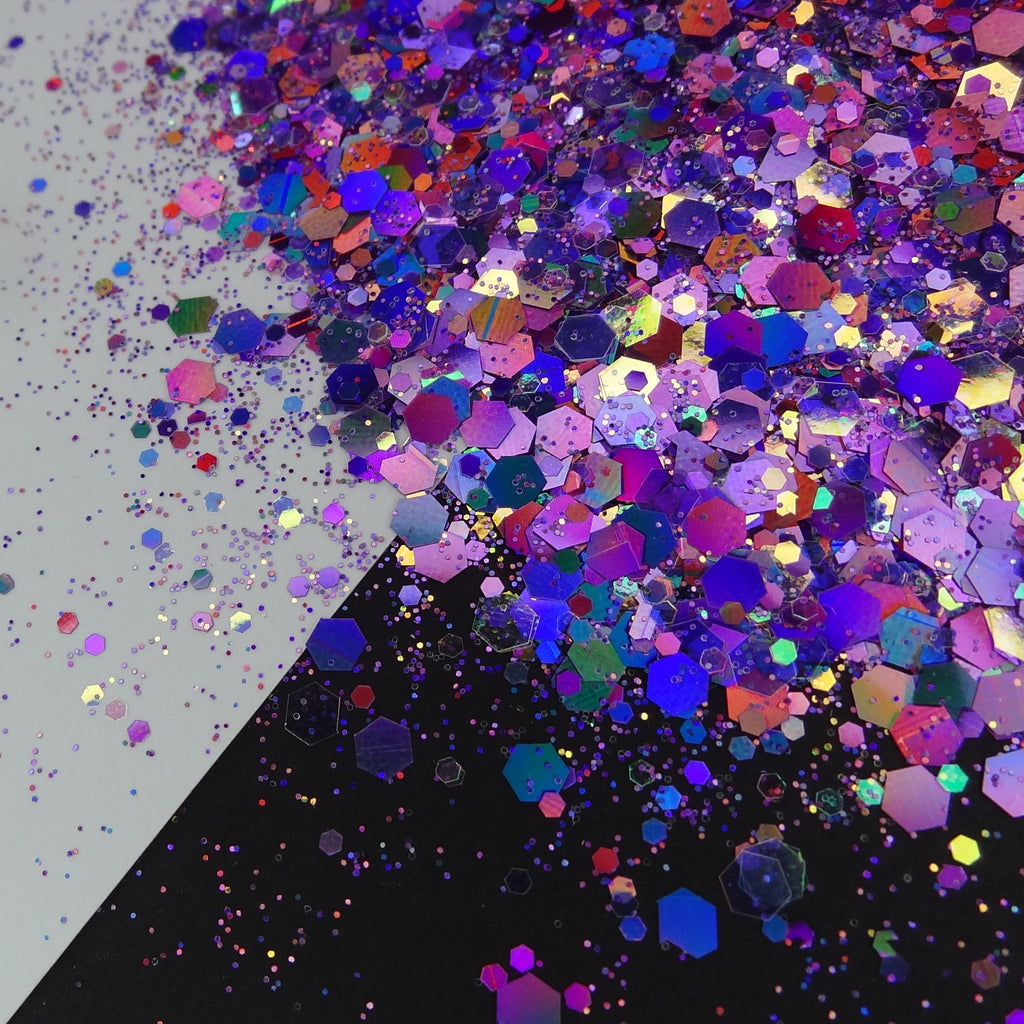 A pile of purple holographic chunky glitter on a black and white background.