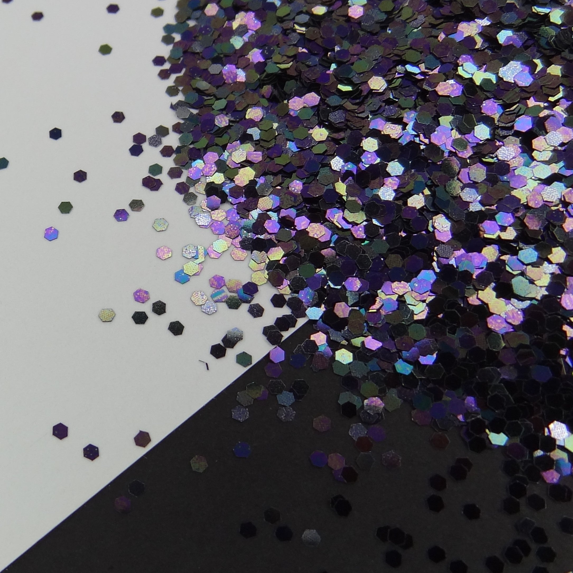 A black pearl medium glitter mix spread out on a black and white background.