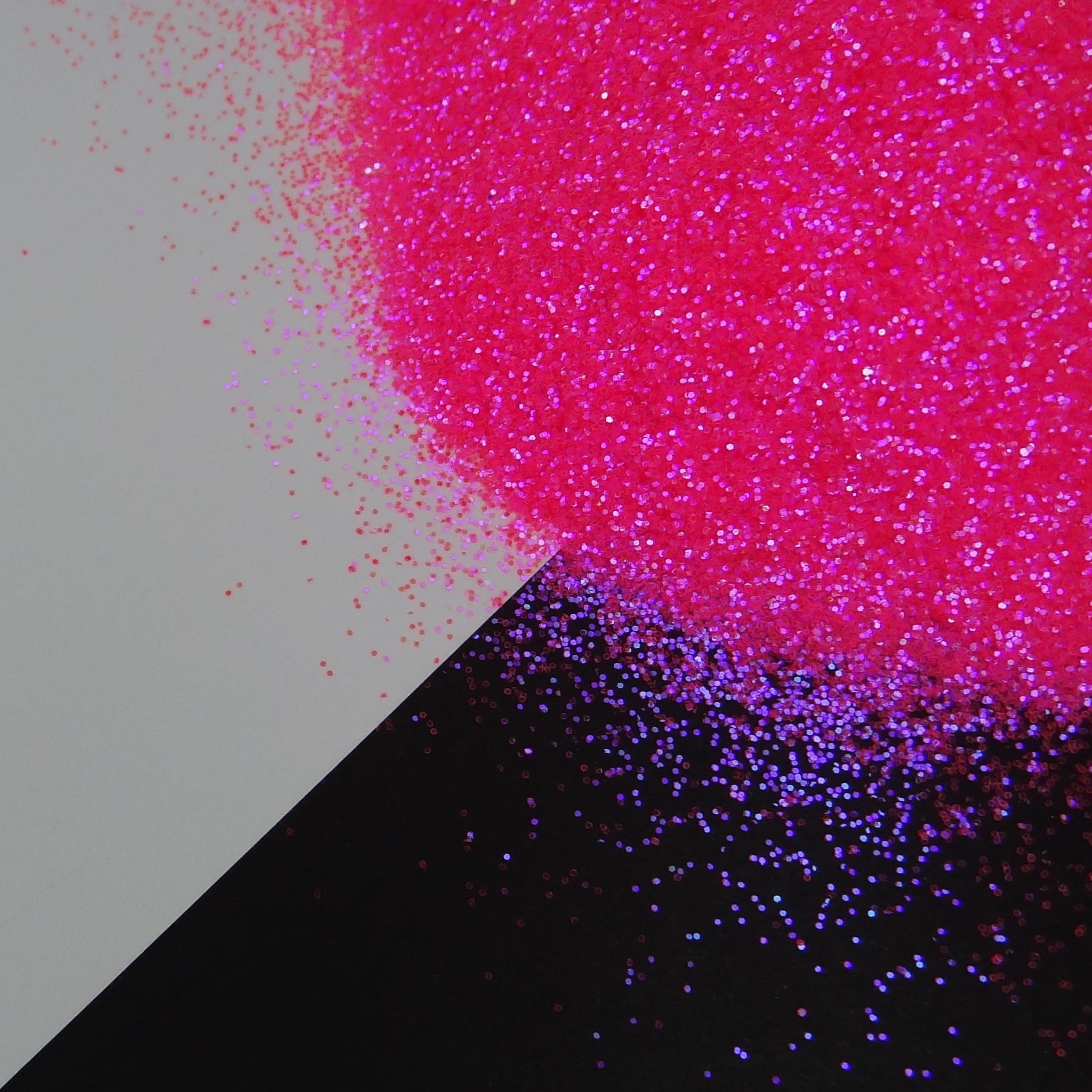 A hot pink extra fine glitter mix spread out on a black and white background.