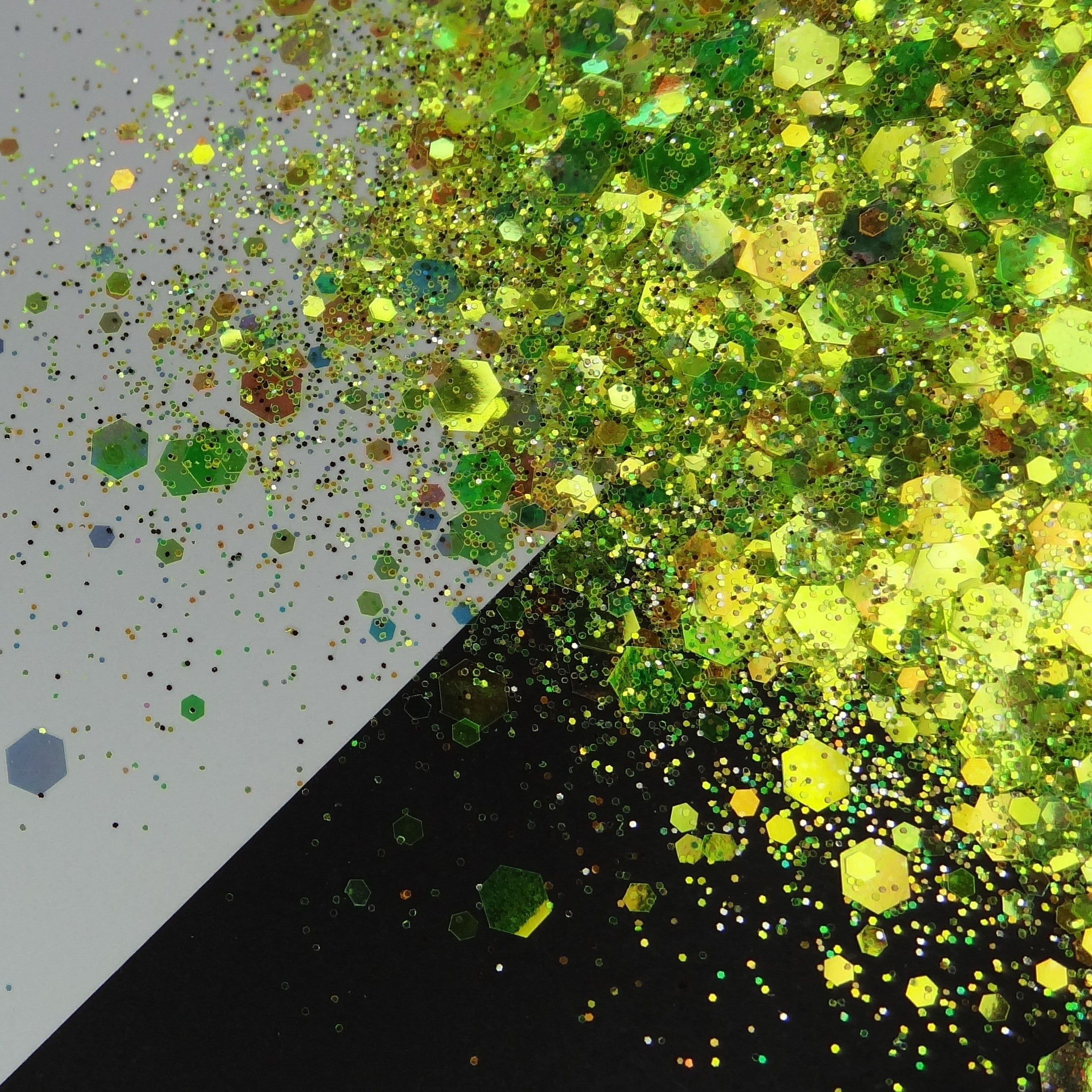 A green/yellow/brown chunky glitter mix spread out on a black and white background.