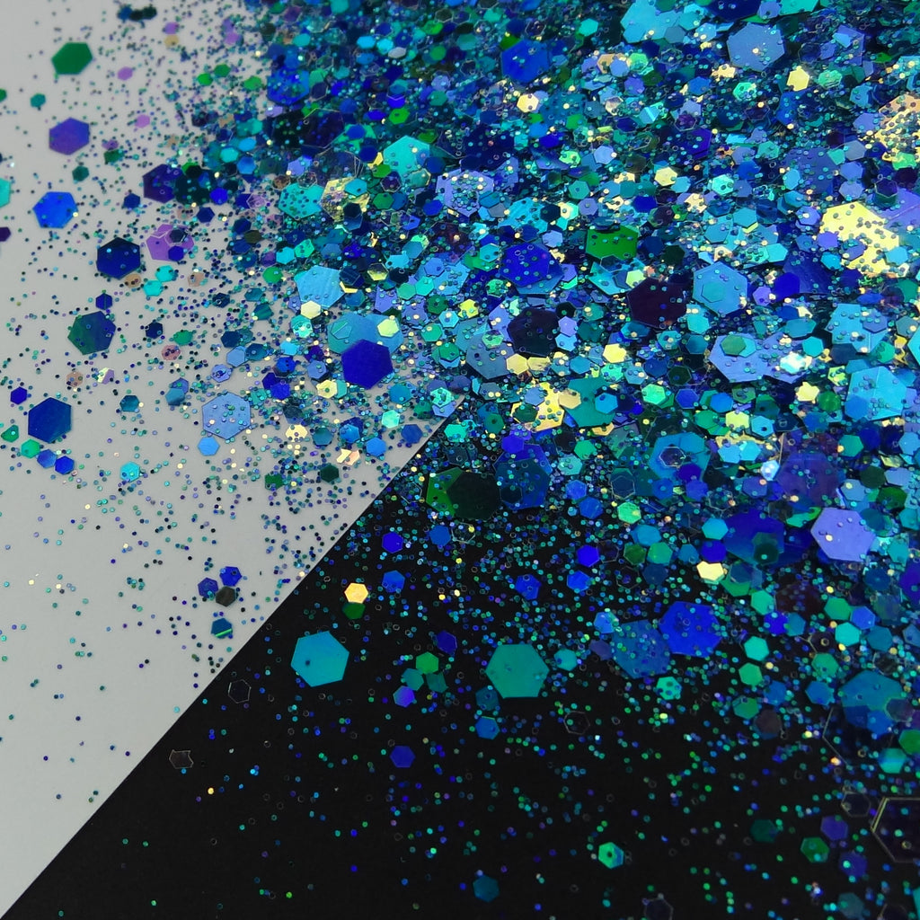 A blue chunky glitter mix spread out on a black and white background.