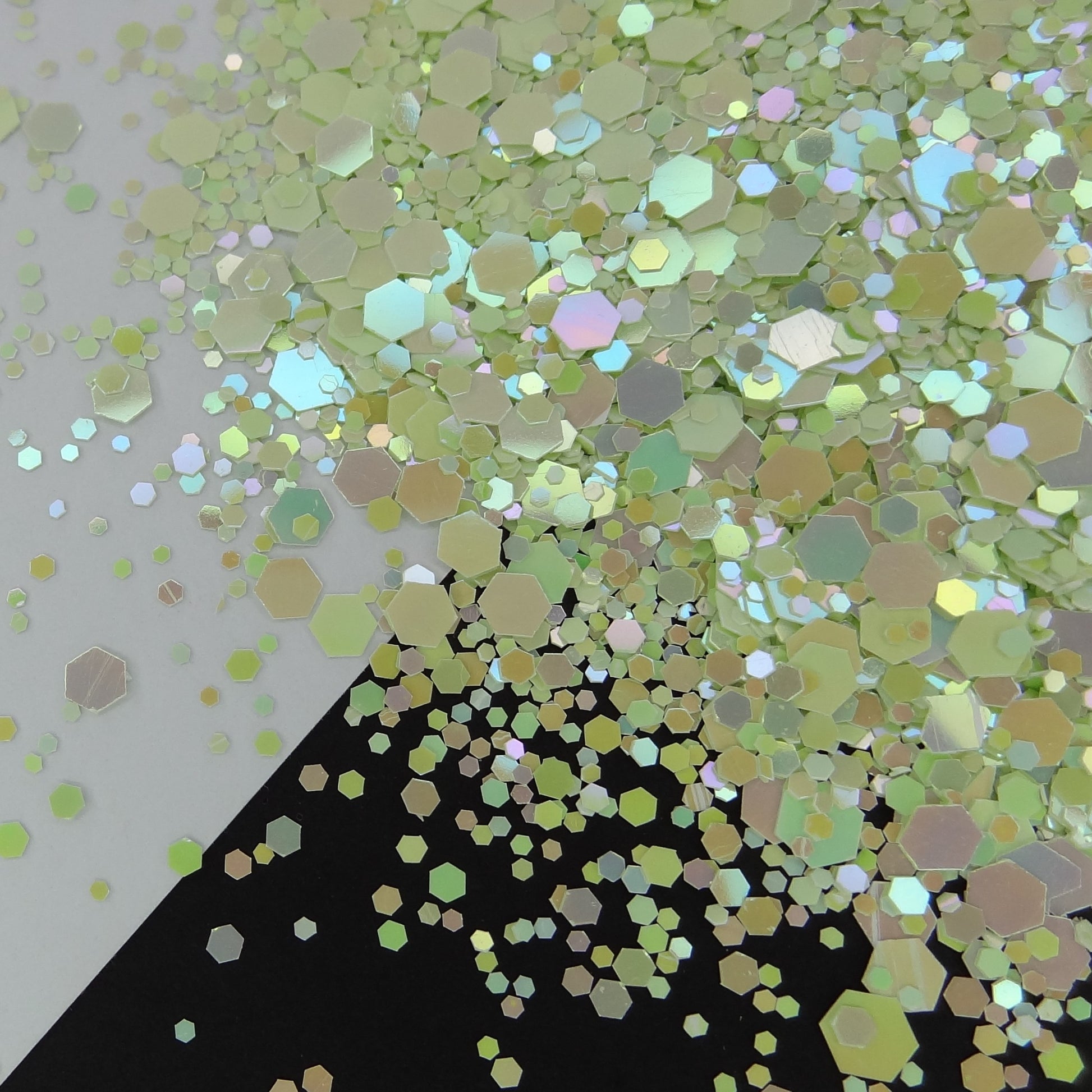 A mint green chameleon rainbow shifting chunky glitter mix on a black and white background.