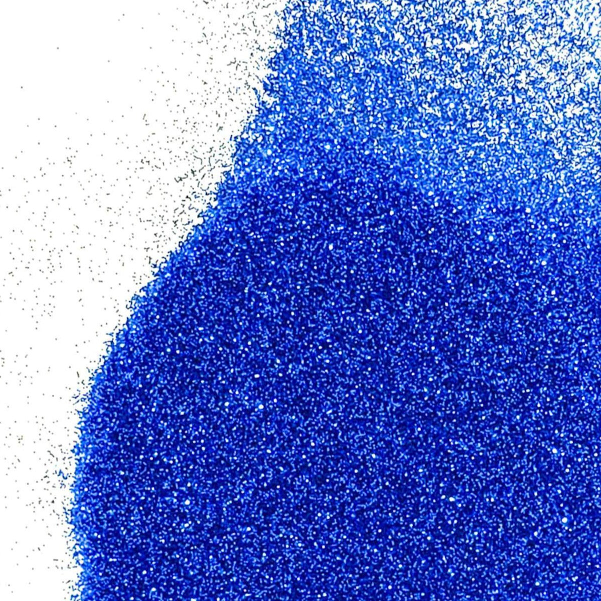 A pile of blue glitter, in extra fine on a white background.