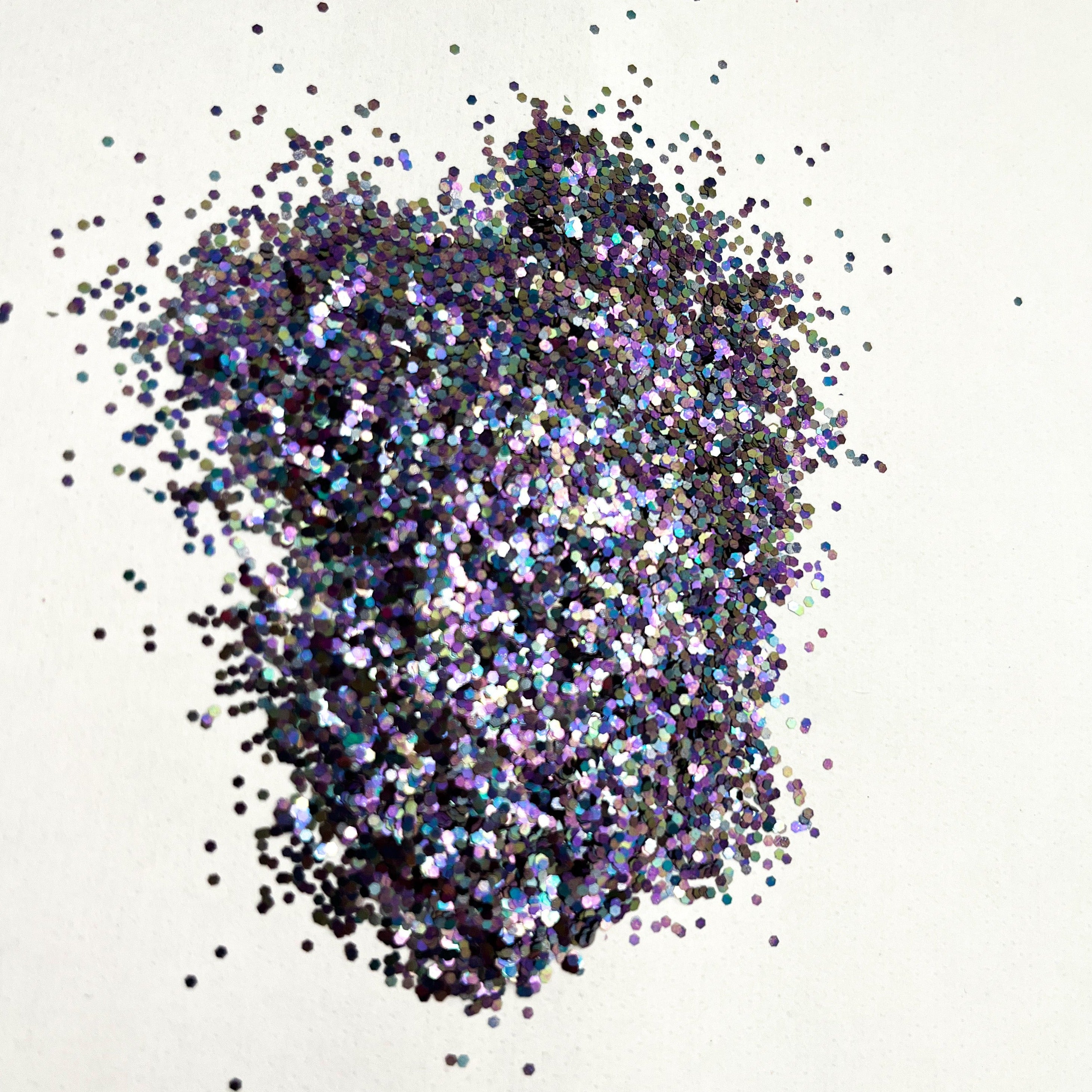 A pile of black pearl, medium cut glitter spread on a white surface.