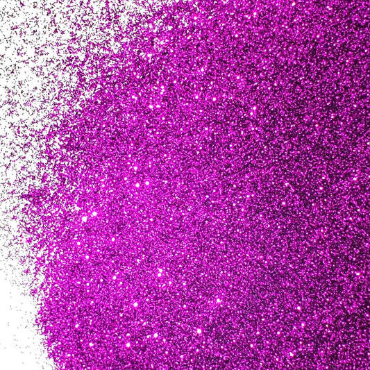 A close-up image of purple glitter spread on a surface, with varying shades of red and pink sparkle throughout.