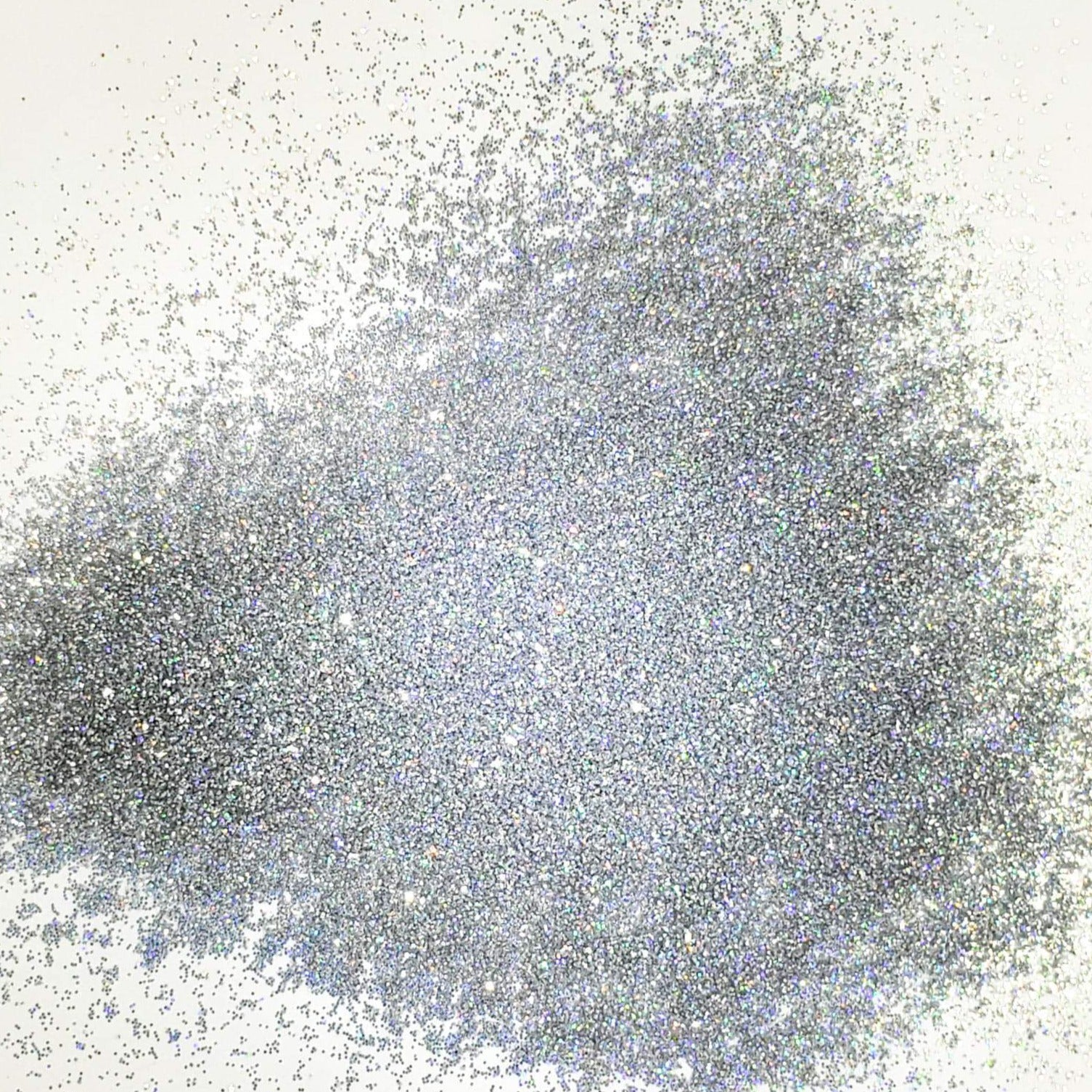 A pile of silver holographic glitter, in extra fine on a white background.