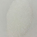 A close-up image of white polyester glitter with a sparkling appearance.