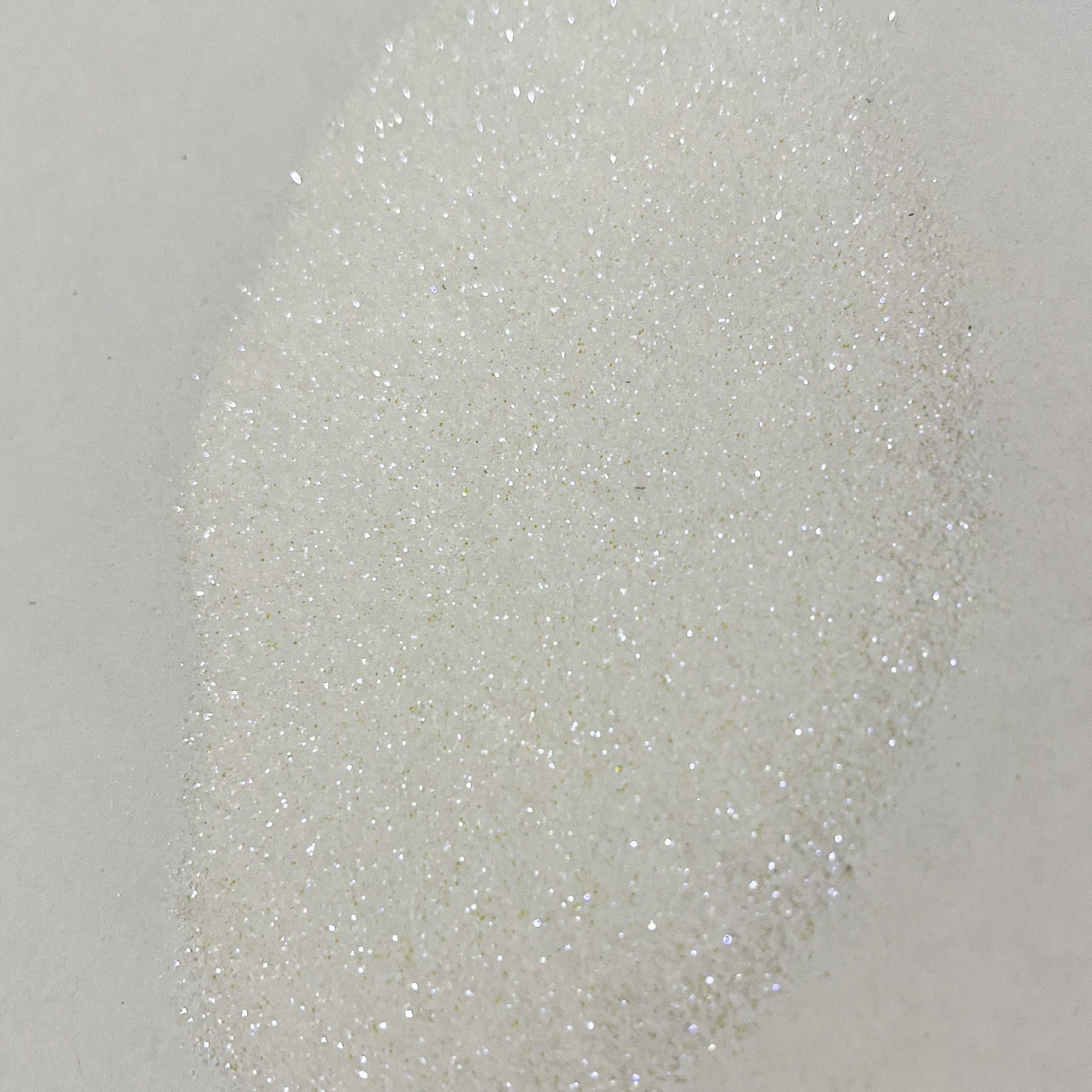 A close-up image of white polyester glitter with a sparkling appearance.