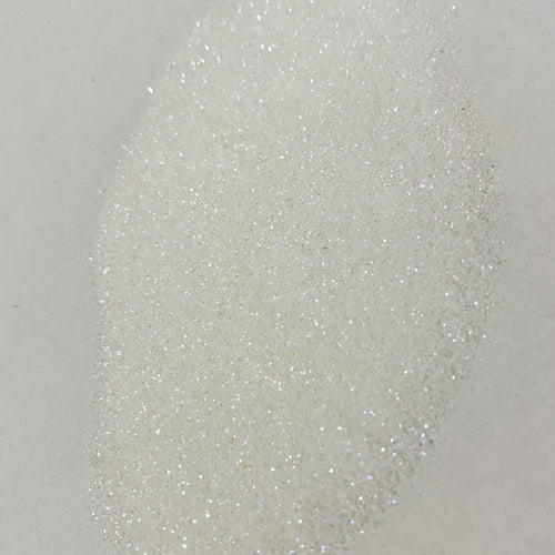 A close-up image of white polyester glitter with a sparkling appearance.